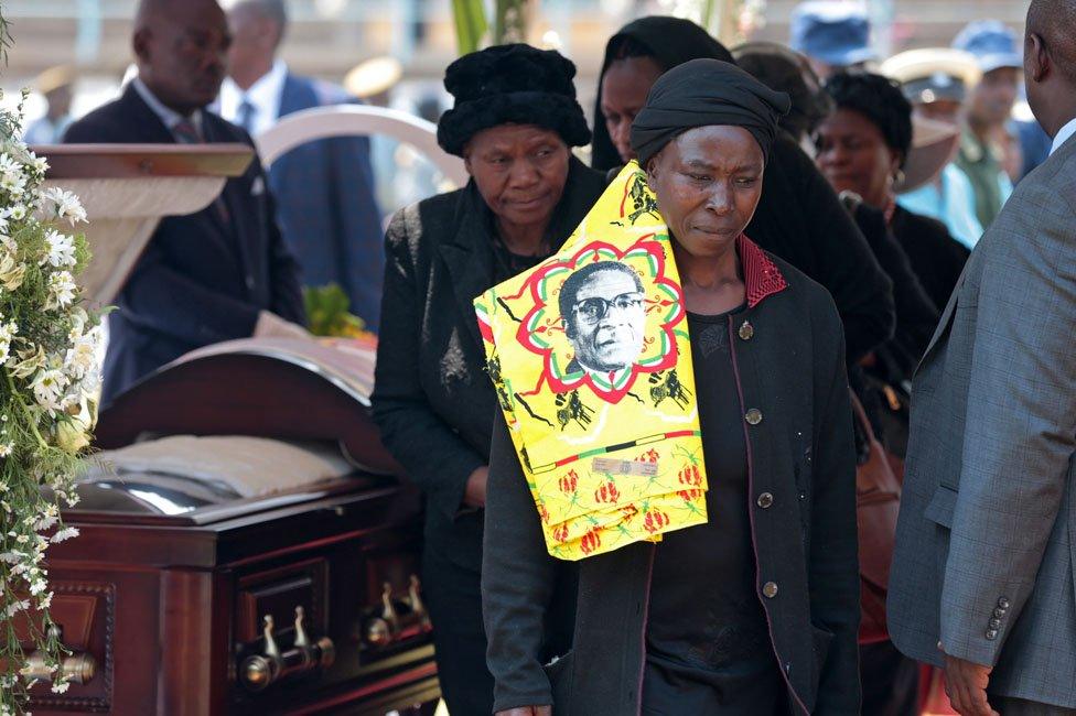 Woman looking sad after viewing coffin