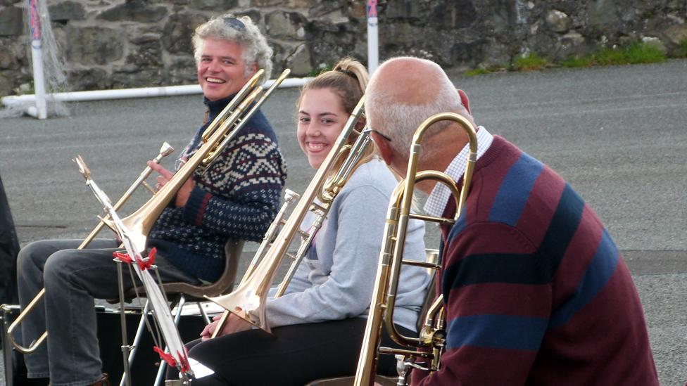 Chwaraewyr trombon yn chwerthin