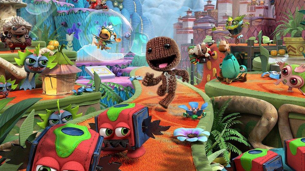 Sackboy walking along a patch surrounded by strange creatures