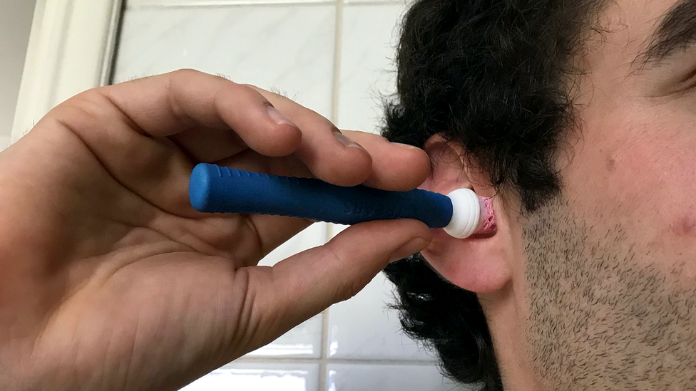 man having ear swabbed