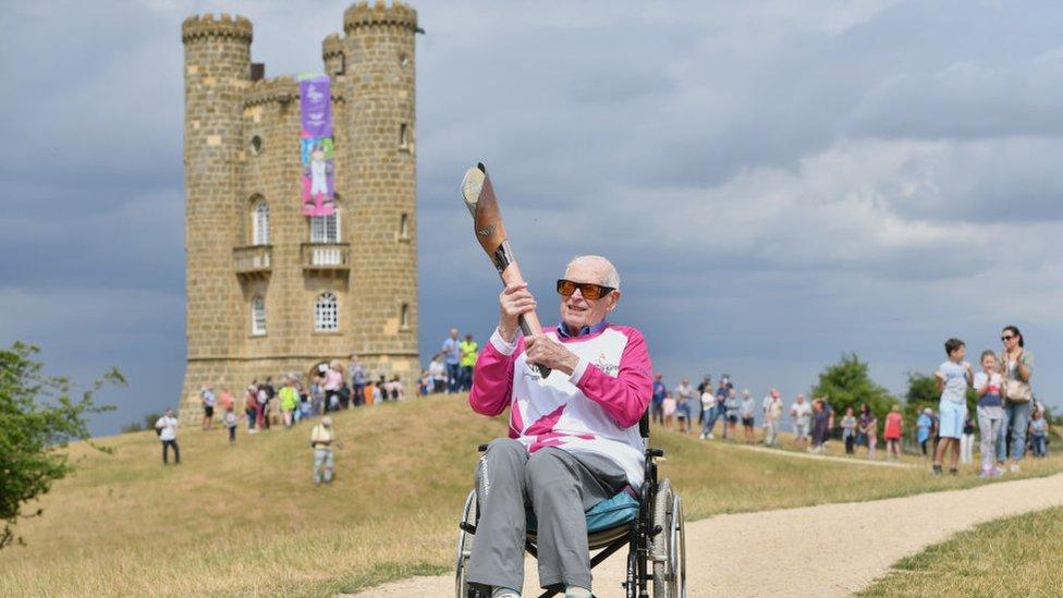 Baton bearer John Farringdon carries the Queen's Baton during the Birmingham 2022 Queen's Baton Relay at a visit to Broadway Tower on July 22, 2022 in Worcestershire