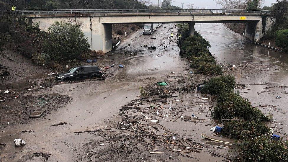 US Highway 101 at the Olive Mill Road overpass flooded with runoff water from Montecito Creek and blocked with mudflow and debris following heavy rains in Montecito, California.