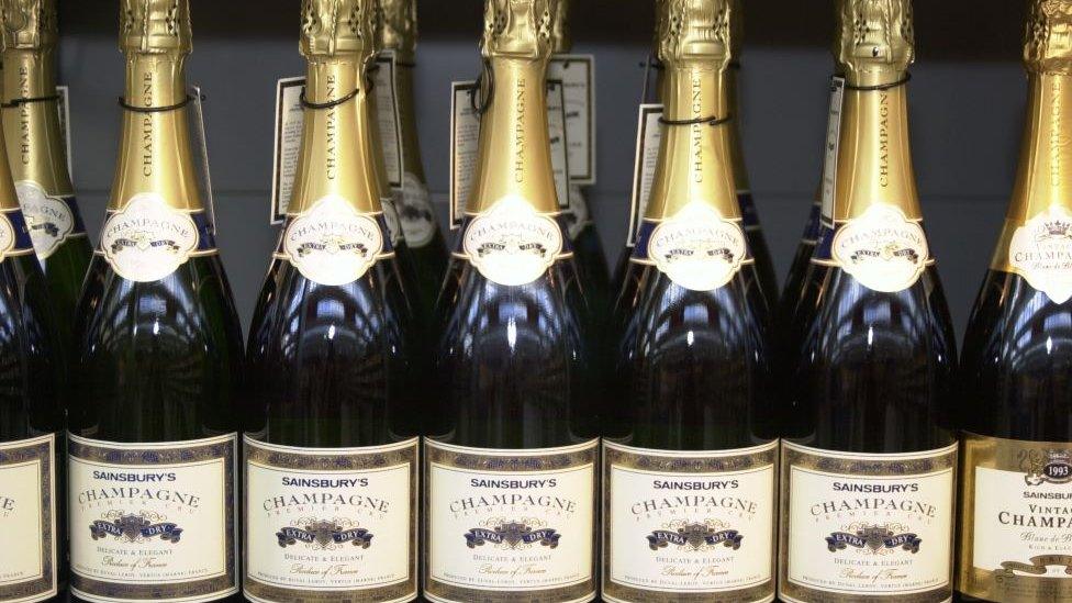 A row of champagne bottles on a shop shelf