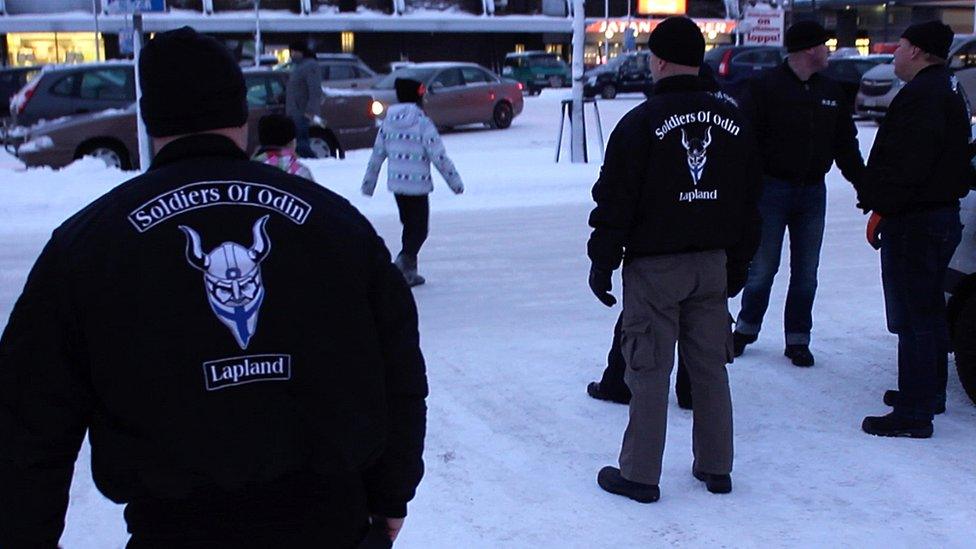 Members of the Soldier of Odin group wearing black jackets with a Viking motif