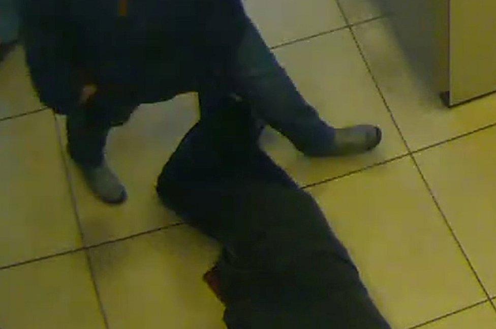 Bank CCTV shows pensioner lying next to cash machines (Essen police photo)