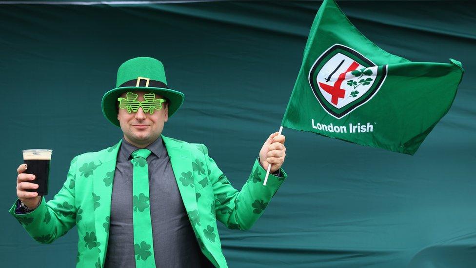 Man holding Guinness and London Irish flag