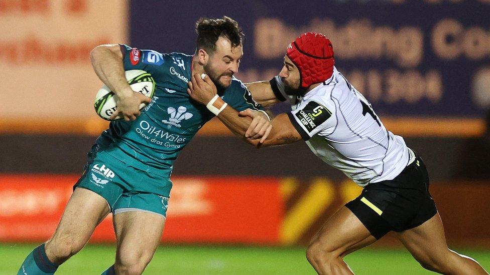 Ryan Conbeer o'r Scarlets yn cael ei daclo gan Akaki Tabutsadze