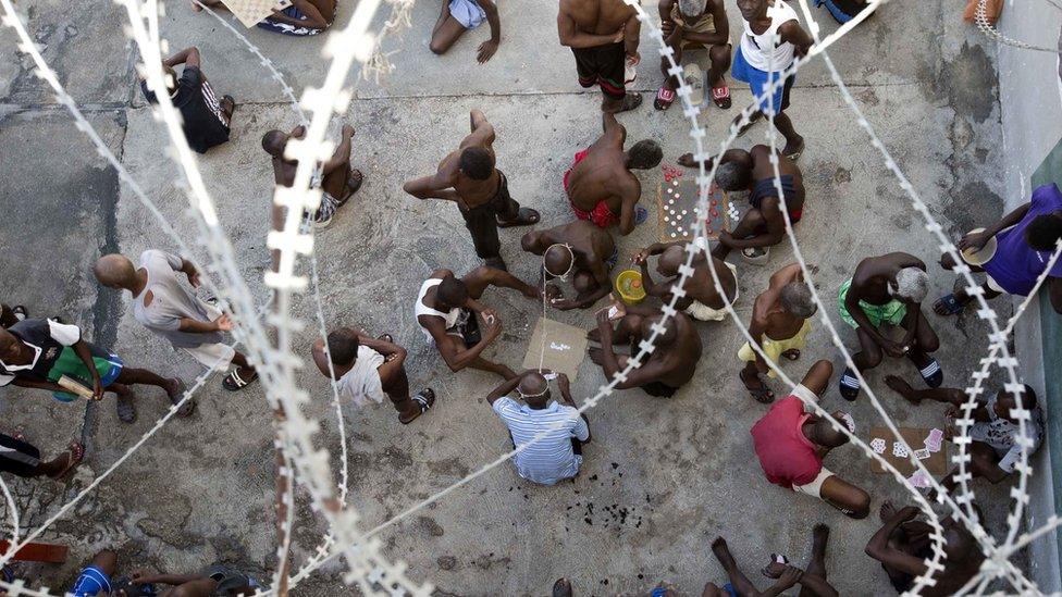 Some prisoners play dominoes, checkers or card games, during recreation time inside the National Penitentiary in downtown Port-au-Prince