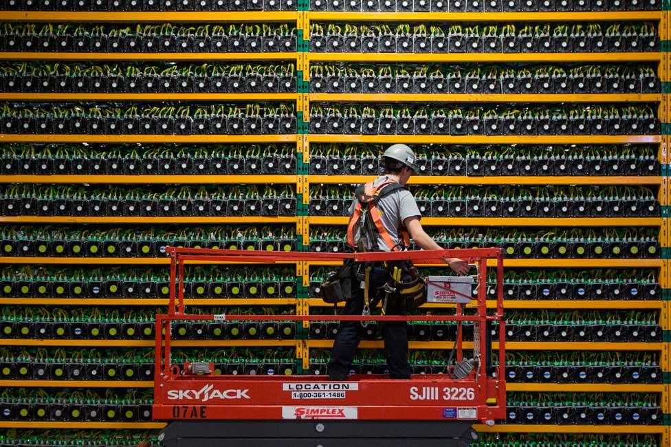 A technician inspects computers mining bitcoin in Quebec