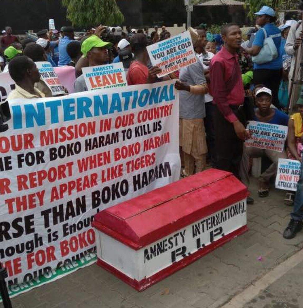 People carry a symbolic coffin, 'amnesty international R.I.P' written on it, during a protest staged against Amnesty International's (AI) 2017 annual report near the AI's office in Abuja, Nigeria on March 22, 2017.