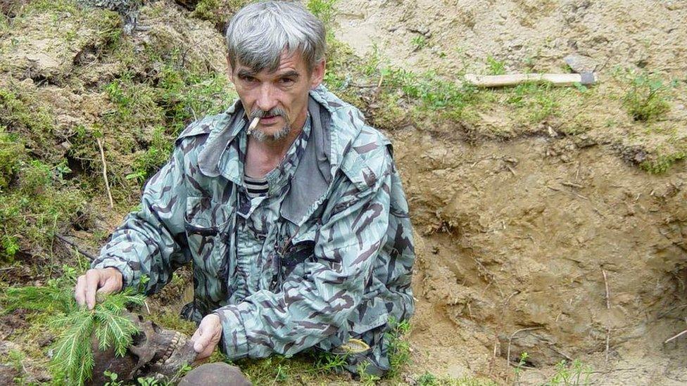 Yuri Dmitriev with victims' skulls at mass grave