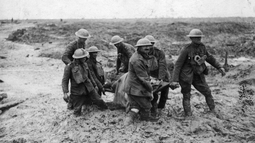 A stretcher-bearing party carrying a wounded soldier through the mud near Boesinghe during the battle of Passchendaele in Flanders