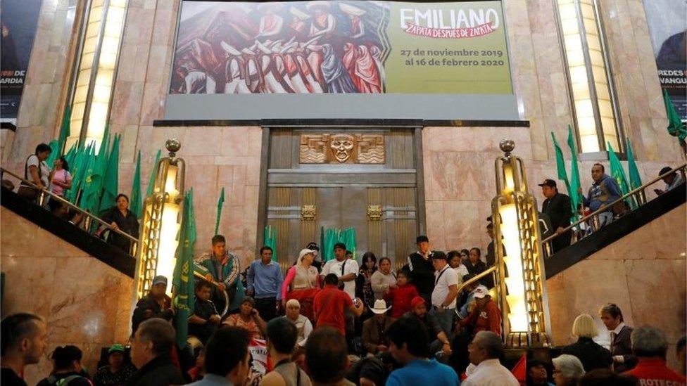 A group of people block the entrance of the Fine Arts Palace to protest against a painting showing Mexican revolutionary hero Emiliano Zapata in Mexico City