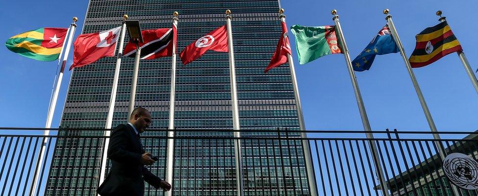 Image shows flags outside the UN headquarters in New York City