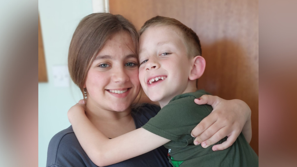 Emilia, 13, and Jakub, 8, hugging each other