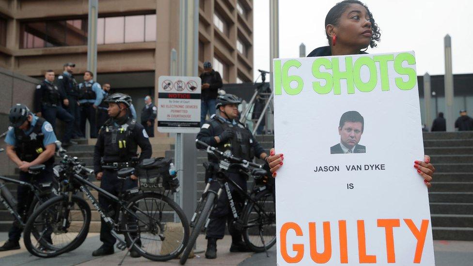 A protester stands outside court after the guilty verdict in the murder trial of Jason Van Dyke in Chicago