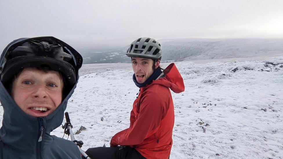 Two cyclists on a snowy mountain