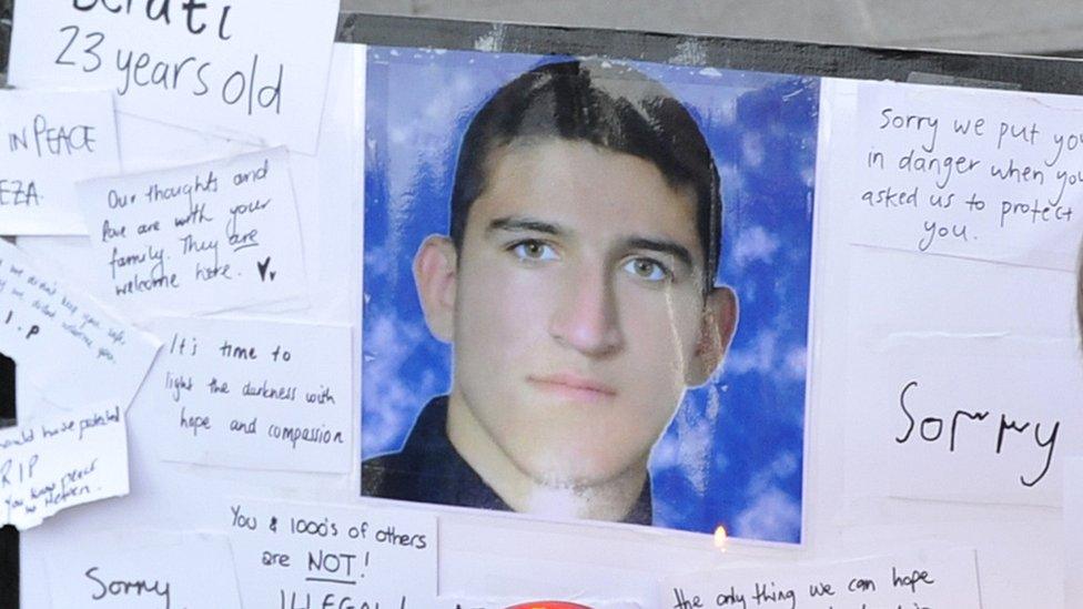 People places flowers and cards next to the portrait of Iranian asylum seeker Reza Berati during a candlelight vigil in support of asylum seekers.