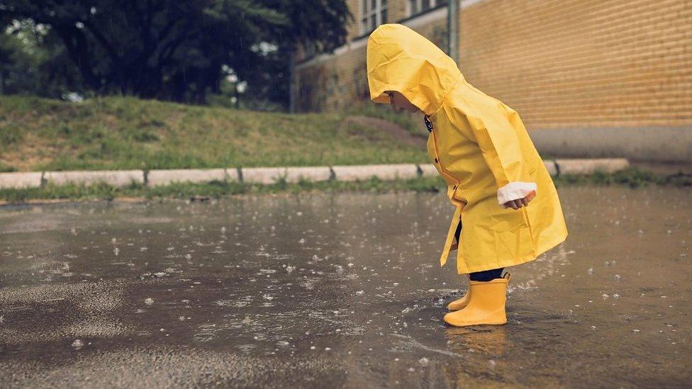 Kid-looks-into-puddle.