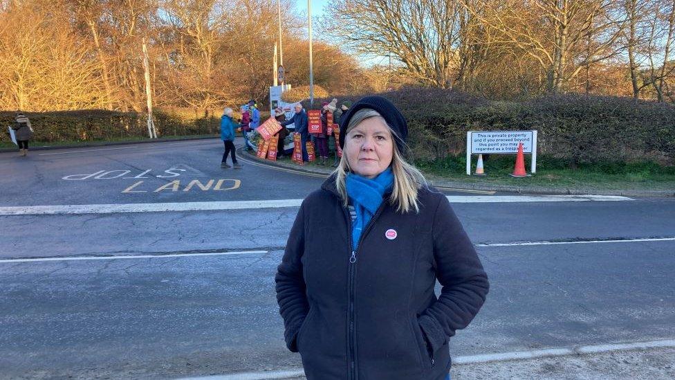 Alison Downes with Sizewell protesters gathered in the background