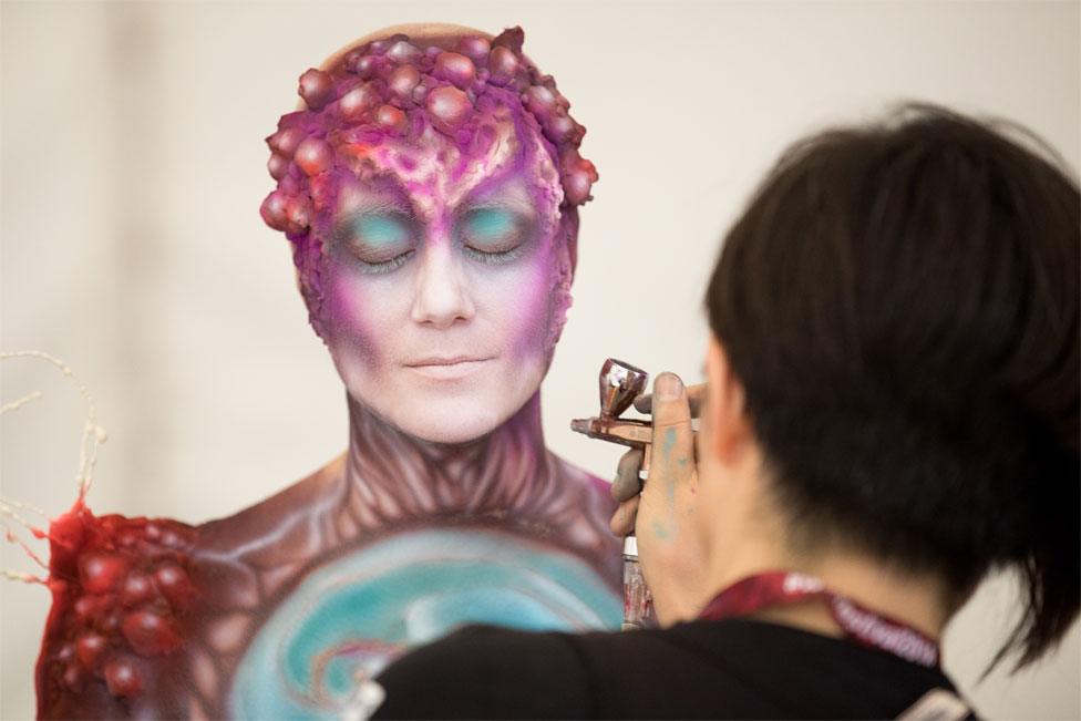 An artist paints a model