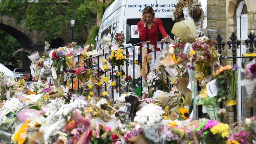 Flowers, photographs and messages of condolences lie at a makeshift memorial for the victims of the Grenfell Tower