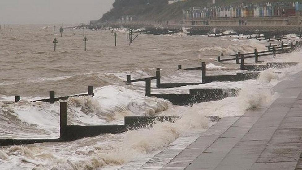 Blustery day in early March showing Felixstowe sea defences with a row of beach huts in the background