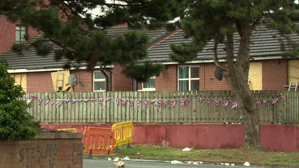 Boards on windows of houses close to a bonfire