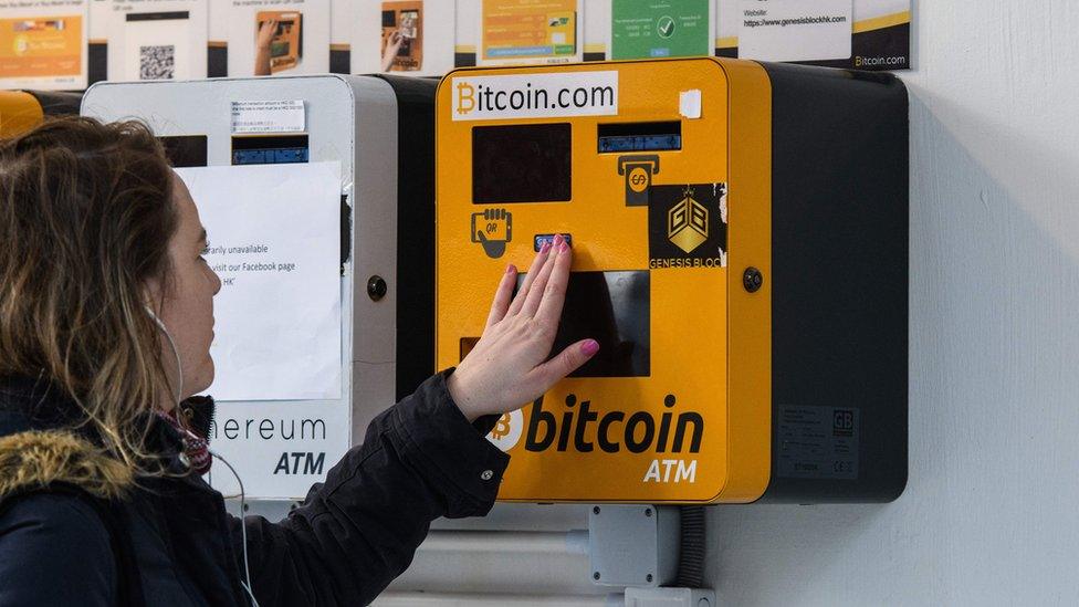 A woman touches an ATM machine for digital currency Bitcoin in Hong Kong on December 18, 2017.