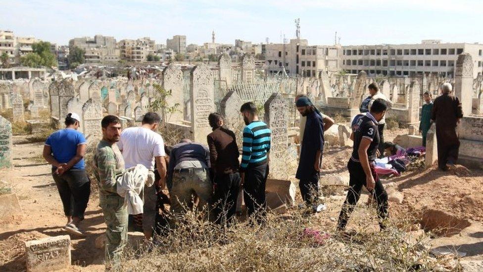 People bury relatives whom died in an airstrike in the rebel held besieged al-Qaterji neighbourhood of Aleppo (16 October 2016)