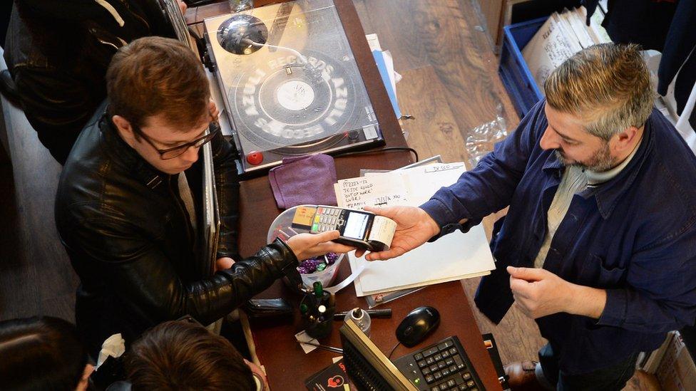 A customer purchases vinyl