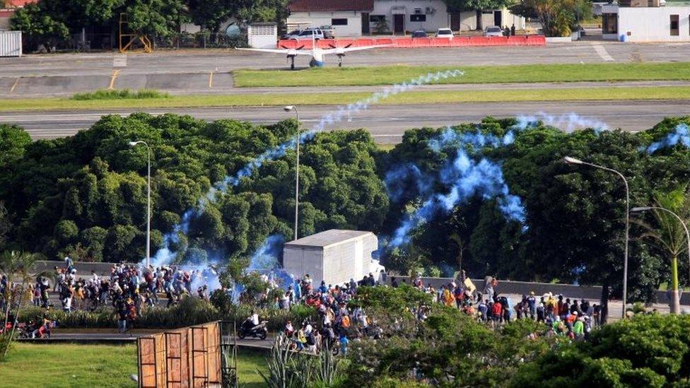 Demonstrators clash with riot security forces in front of the fence of an air base while rallying against Venezuela's President Nicolas Maduro in Caracas, Venezuela, May 31, 2017.