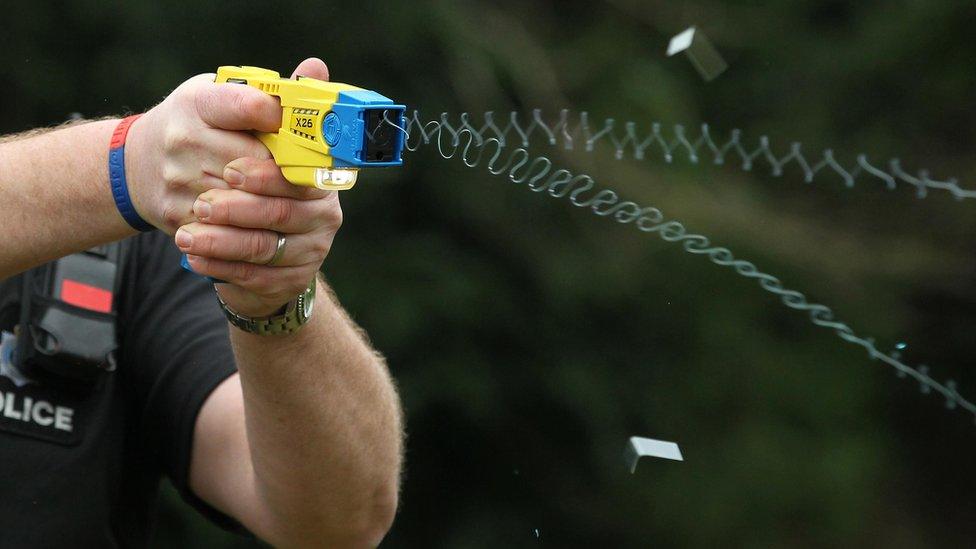 Police officer firing a Taser