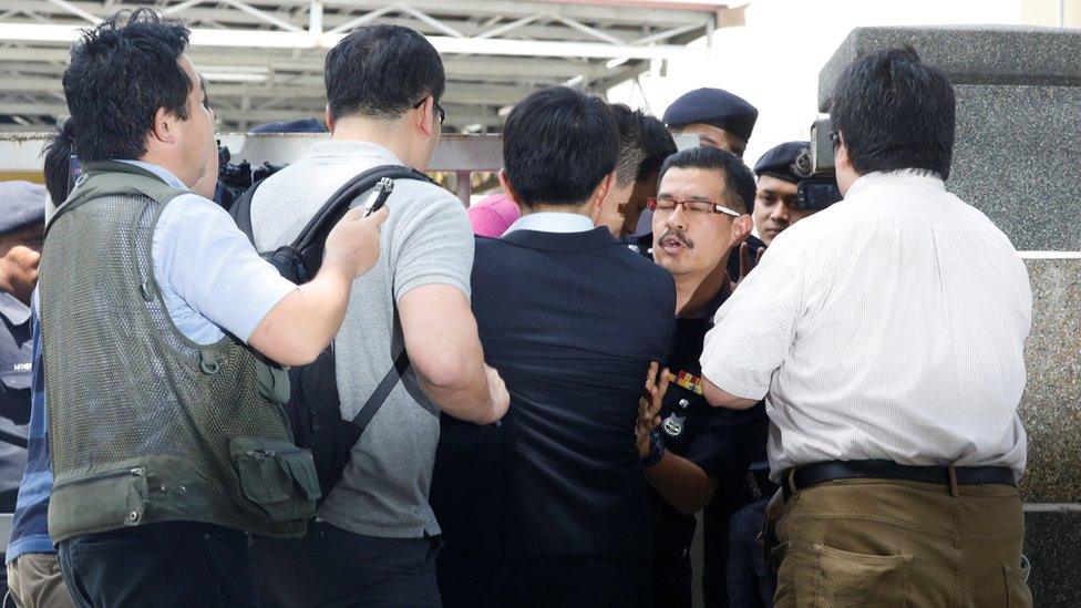 Journalists scuffle with a police officer as they try to interview a North Korea official at the morgue at Kuala Lumpur General Hospital where Kim Jong Nam"s body is held for autopsy in Malaysia February 15, 2017