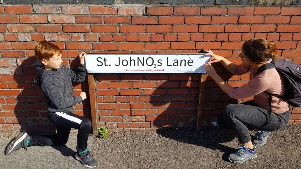 Deborah Vittori and son next to street sign