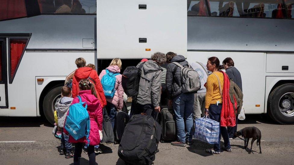 Ukrainian refugees from Mariupol region board a bus bound for Poland at a registration and humanitarian aid centre in May 2022