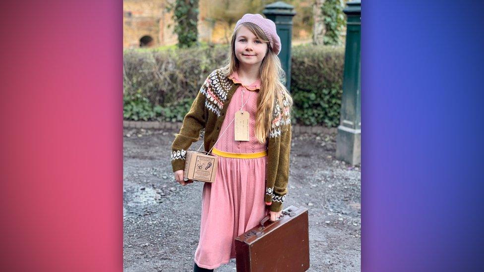 girl wearing 1940s style clothes and holding a ration box