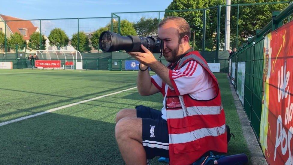 Dan Andrade taking a photo of a football match