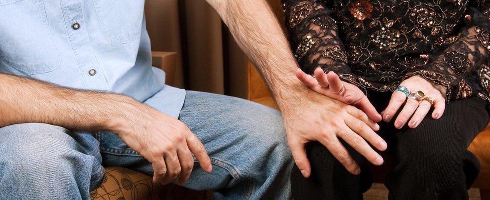 Woman pushing man's hand away