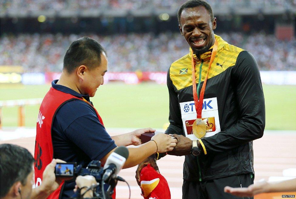 Usain Bolt receives a present from Tao Song, a cameraman with CCTV - 28 August 2015