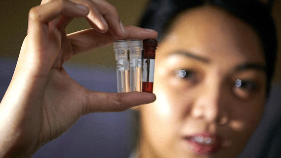 Woman with phial of samples