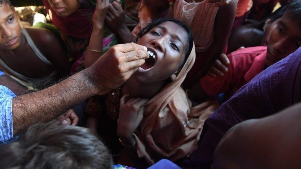 A Rohingya refugee receives an oral cholera vaccine from a Bangladeshi volunteer at the Thankhali refugee camp in Ukhia district (10 October 2017)