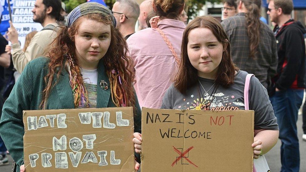 Anti racism rally Dunmurry, two girls holding signs