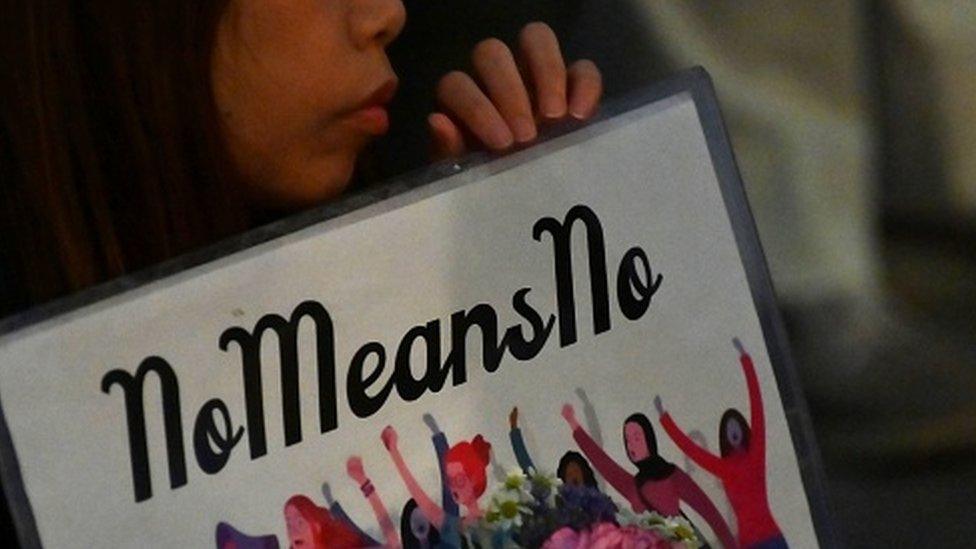 A demonstrator holds a placard during a protest against the lack of substantial legal protection for sexual assault victims in Tokyo