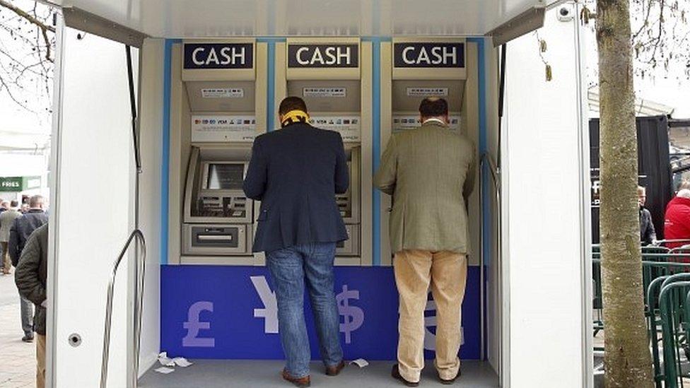 Two customers at a cashpoint