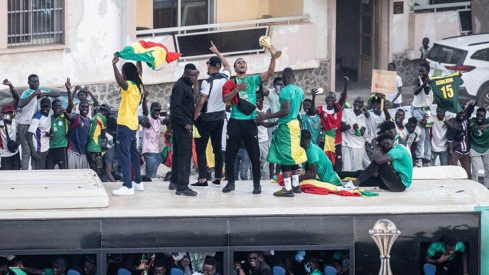 Supporters cheer on a bus