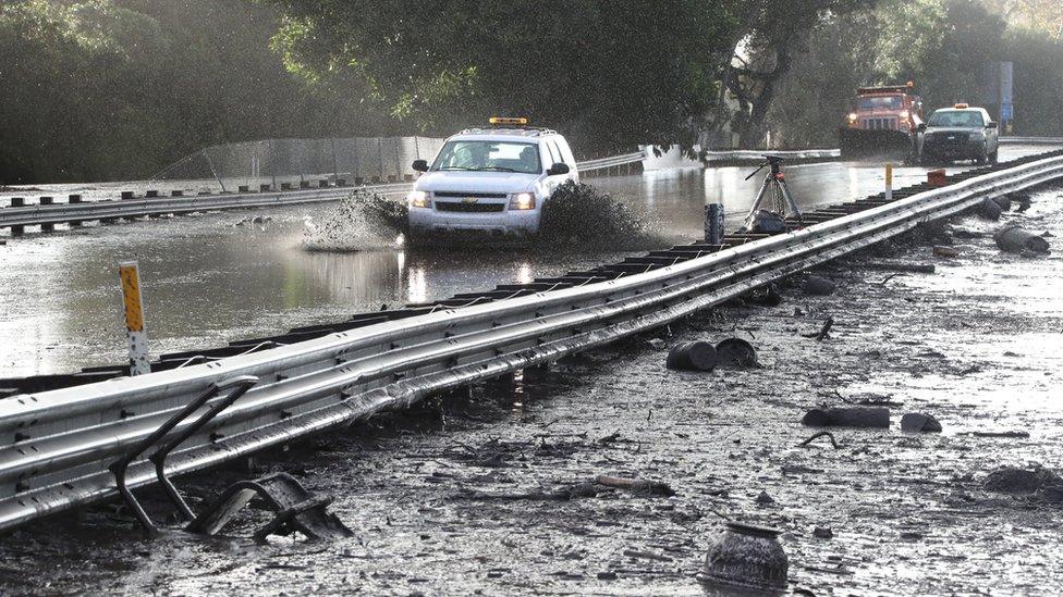 An emergency vehicle makes its way through mud on Highway 101 after heavy rains caused deadly mudslides in Montecito, California.