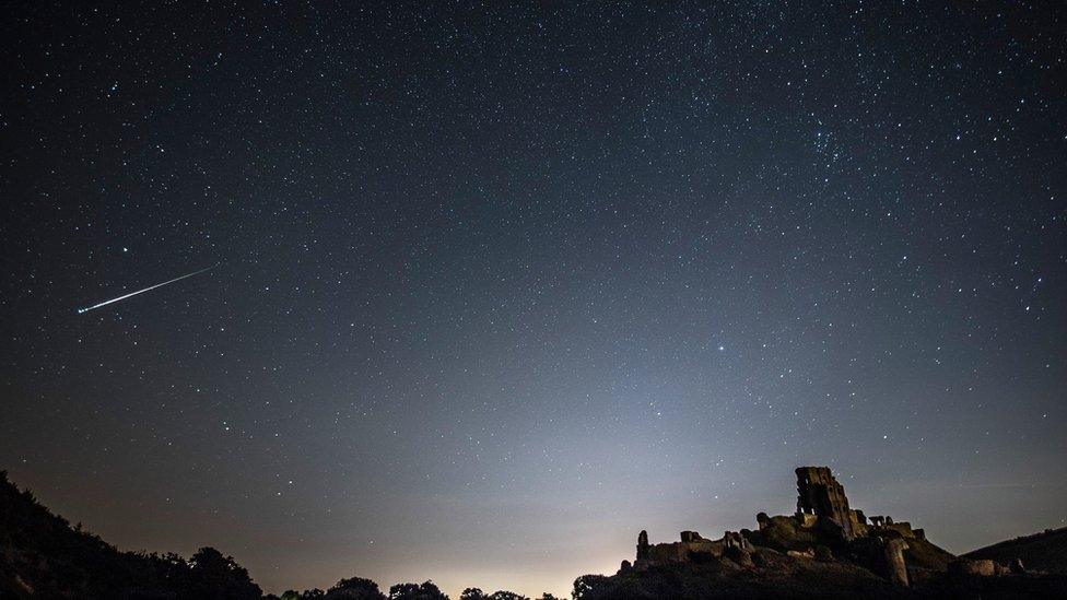 A Perseid Meteor flashes across the night sky above Corfe Castle on August 12, 2016 in Corfe Castle, United Kingdom.