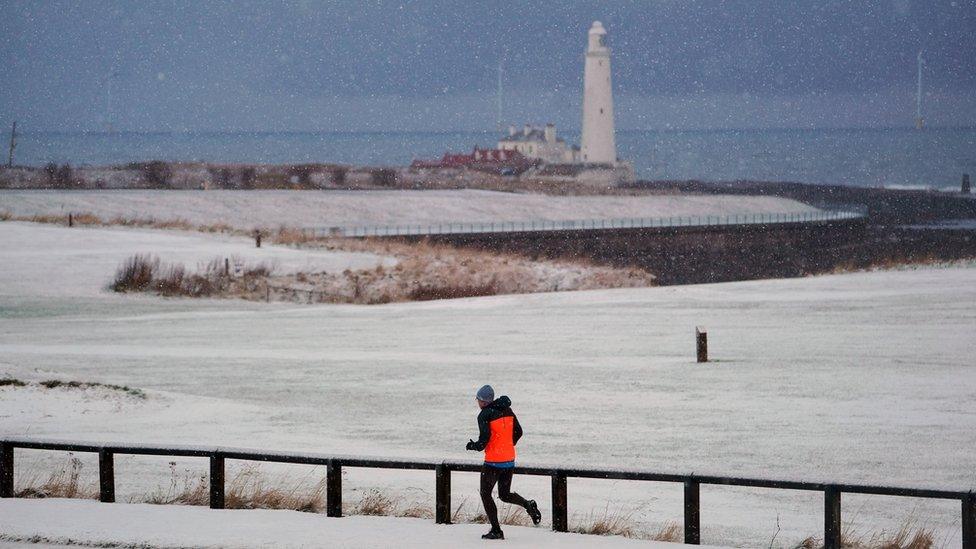 A jogger runs past St Mary"s Lighthouse in Whitley Bay on the Northumberland coast.