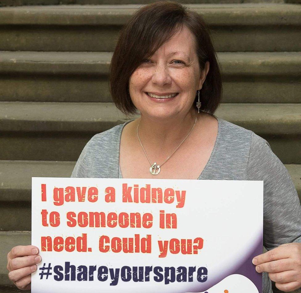 Tracey Jolliffe holds a sign saying 'I gave a kidney to someone in need, could you?'